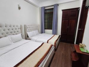 a bedroom with two beds and a table and a window at The Cloud Hotel in Da Lat +11 photos