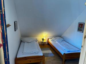 two beds in a small room with a lamp at Ferienhaus Seenelke in Neßmersiel