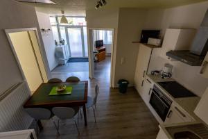 a small kitchen and dining room with a table and chairs at Ferienwohnung Krabbe in Dornum