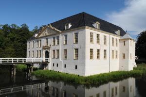 a large white building with a bridge over a river at Ferienwohnung Krabbe in Dornum