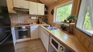 a kitchen with white cabinets and a sink and a window at Ferienhaus Bambi in Haren