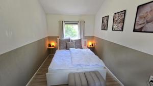 a bedroom with a large white bed with two lamps at Ferienhaus Bambi in Haren