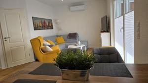 a living room with a blue couch and yellow chairs at Ferienhaus Margarete in Dornumersiel