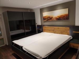 a bedroom with a large bed and a large painting on the wall at Ferienhaus Wiesenpieper in Dornum