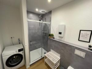 a bathroom with a shower and a washing machine at Ferienhaus Margarete in Dornumersiel +9 photos