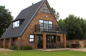 a house with a gambrel roof and a deck at Ericka's Luxurious Guesthouse in Vaal Marina