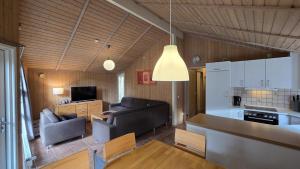 a living room with a couch and a table and a kitchen at Ferienhaus Eichhörnchenhöhle in Haren