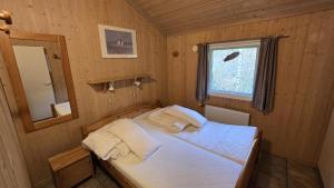 a small bedroom with a bed and a mirror at Ferienhaus Eichhörnchenhöhle in Haren