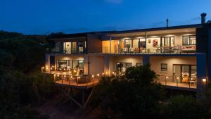 a large house with lights on the balcony at night at SuPaViews in Wilderness