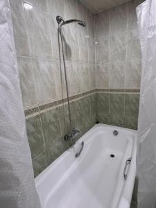 a white bath tub in a bathroom with a shower at LevelUp ApartHotel in Baku