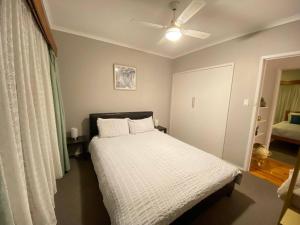 a bedroom with a bed and a ceiling fan at Private 3Bed Home with Large Deck Central Location in Eaglehawk