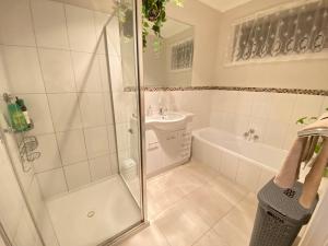 a bathroom with a shower and a tub and a sink at Private 3Bed Home with Large Deck Central Location in Eaglehawk +16 photos