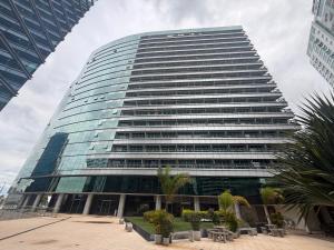 a tall glass building with trees in front of it at Vision Hotel - Flat Particular in Brasília