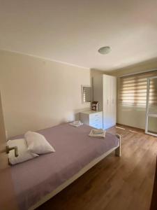 a bedroom with a large bed and a wooden floor at Apartments Luna in Bar