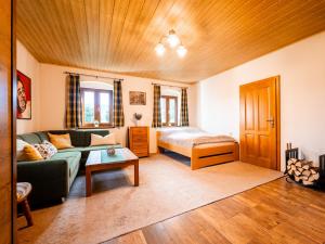 a living room with a couch and a bed at Chalupa Sibřinka in Korkusova Huť