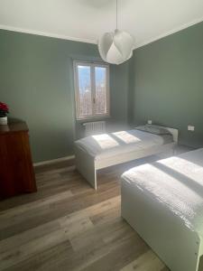a bedroom with two beds and a window at Ca Sunder in Sondrio