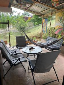 a porch with chairs and a table and a hammock at Casa compartida - Las 5 Quintas in San Rafael