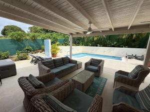 a patio with wicker furniture and a swimming pool at Jacks Place - by ZenBreak in Saint Peter
