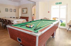 a living room with a pool table and a table at Spacious Buxton house with hot tub and pool table in Norwich