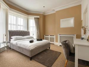 a bedroom with a bed and a desk and a chair at Spacious Buxton house with hot tub and pool table in Norwich +35 photos