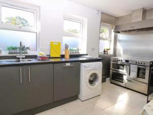 a kitchen with a washing machine and a washer at Spacious Buxton house with hot tub and pool table in Norwich