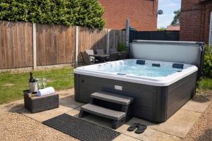 a jacuzzi tub in a backyard with a table at Spacious Buxton house with hot tub and pool table in Norwich
