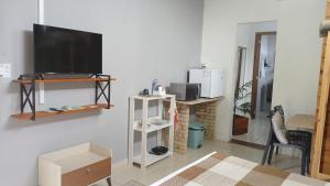 a living room with a flat screen tv on a wall at Suíte 77 privativa , há 11km da vila germânica in Blumenau