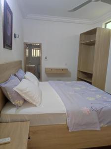 a bedroom with a large bed with pillows on it at Amazing Grace Residence in Cotonou