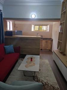a living room with a red couch and a table at Amazing Grace Residence in Cotonou