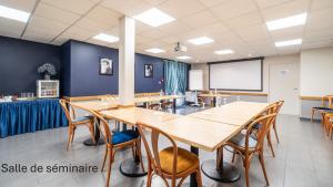 a conference room with wooden tables and chairs at Kyriad Direct Limoges Nord in Limoges