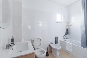 a white bathroom with a toilet and a sink at Santana Lens & Trail House in Santana +18 photos