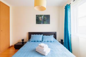 a bedroom with a blue bed with towels on it at Santana Lens & Trail House in Santana