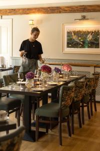 a woman standing at a table in a restaurant at The Bianconi Inn in Killorglin