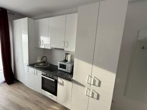 a kitchen with white cabinets and a sink and a microwave at VISAJ Jacuzzi Romantic in Timişoara