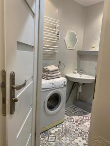 a small bathroom with a washing machine and a sink at Apartament 94 Konin in Konin