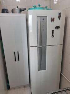 a white refrigerator with magnets on it in a kitchen at Studio Playcenter in Campos dos Goytacazes