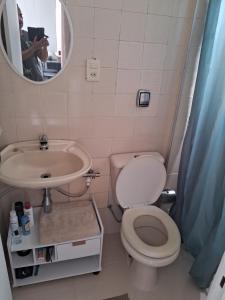 a bathroom with a toilet and a sink and a mirror at Studio Playcenter in Campos dos Goytacazes