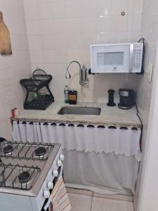a kitchen with a sink and a stove and a microwave at Studio Playcenter in Campos dos Goytacazes +4 photos