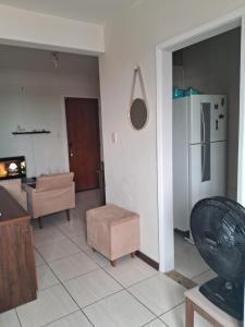 a living room with a couch and a refrigerator at Studio Playcenter in Campos dos Goytacazes