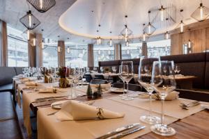 a long table in a restaurant with wine glasses at Postresidenz am See in Arosa
