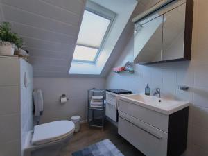 a bathroom with a sink and a toilet and a window at Gästehaus Schuppe in Tarp in Tarp +29 photos
