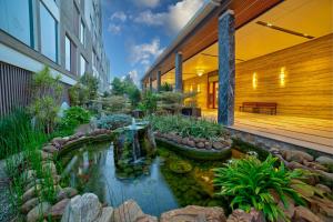 a garden with a pond in front of a building at VRR Astoria Hotel & Convention Center in Bangalore
