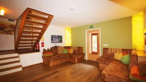 a living room with two couches and a staircase at Alpin-Chalet Flachau in Flachau