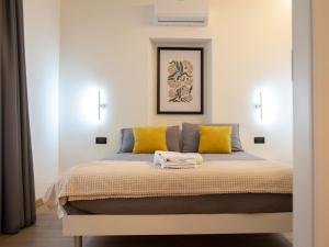 a bedroom with a bed with yellow pillows at Foresteria Dambro rooms -2 Min walk to Bernina Express in Tirano