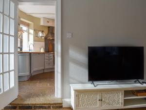 a living room with a flat screen tv on a entertainment center at St Georges Cottage in Holmfirth