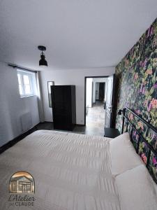 a bedroom with a large bed with a floral wall at L'Atelier de Claude in Wattwiller