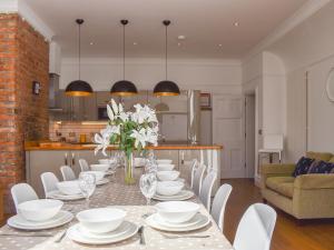 a dining room with a long table with white chairs at Scarborough Esplanade in Scarborough +37 photos