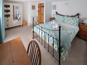 a bedroom with a bed and a wooden table at The Cottage in Broadstairs
