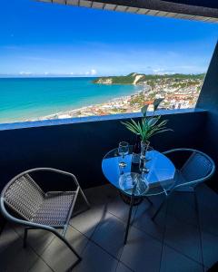a table and chairs with a view of the beach at NATAL PLAZA PONTA NEGRA in Natal