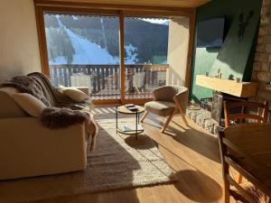 a living room with a large window with a mountain view at Morz'Inn Vue panoramique sur les montagnes in Morzine